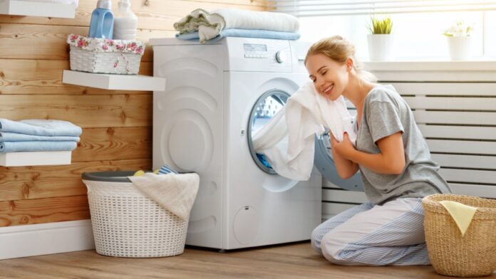 a Happy housewife woman in laundry room with washing machine